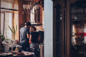 A man and woman standing in front of an oven.