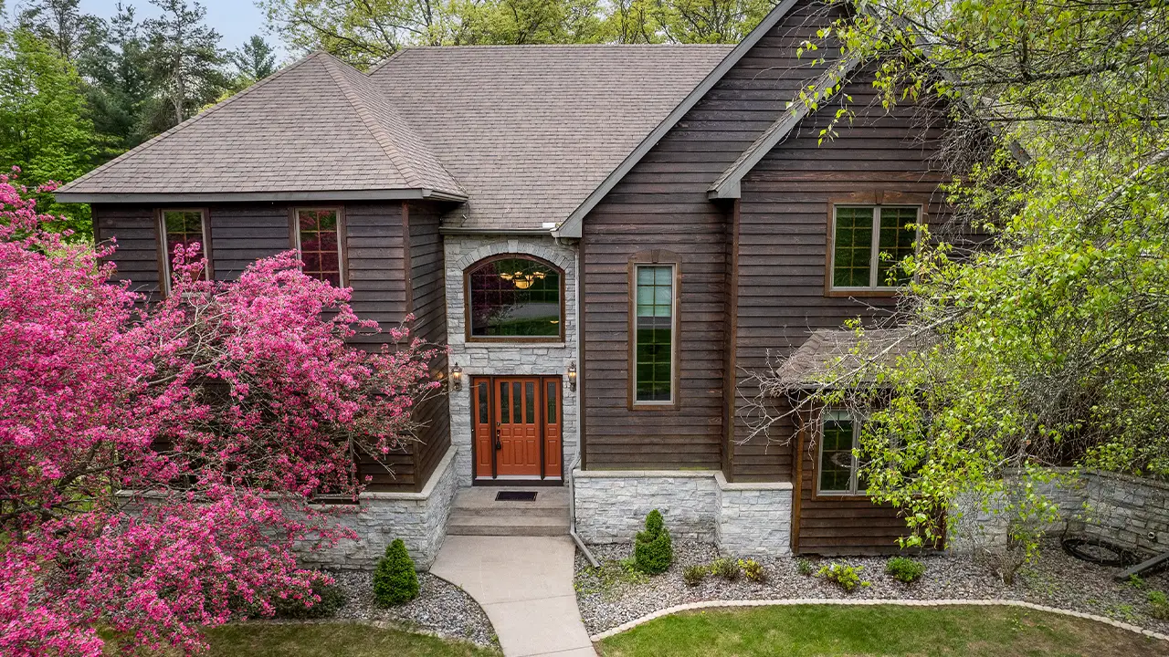 A house with a red door and a pink tree