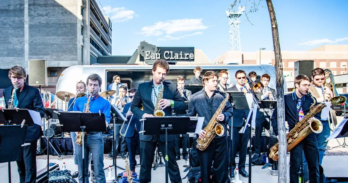 A group of people playing musical instruments on the street.