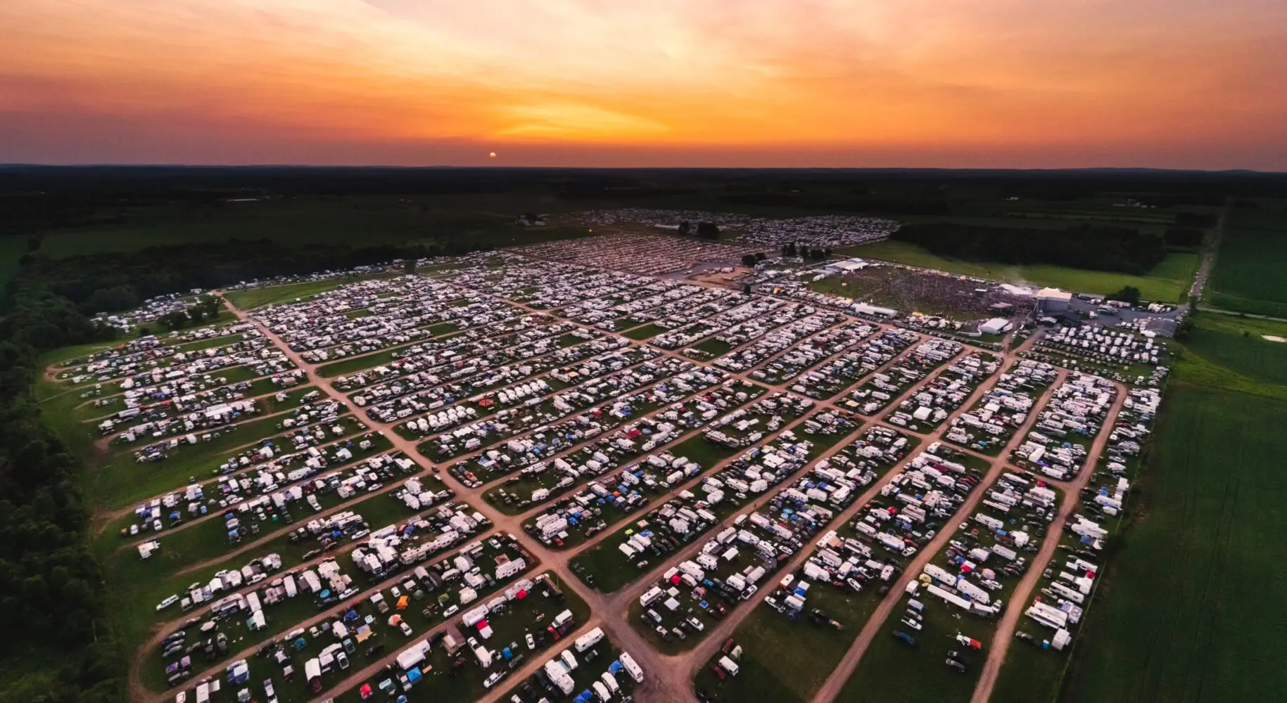 An aerial view of a large field with many trailers parked in it.